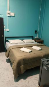 99Hostel&Bar Koh Chang في كو تشانغ: سريرين في غرفة زرقاء وعليها مناشف +4 صور