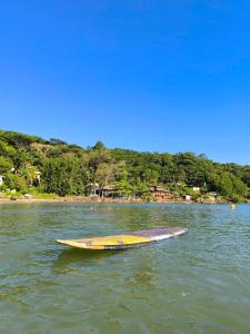 Cantinho do Sonho - Chalé Areia في باليوسا: قارب أصفر يجلس في الماء بالقرب من الشاطئ