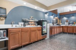 a large kitchen with wooden cabinets and a refrigerator at AmericInn by Wyndham Lake City in Lake City