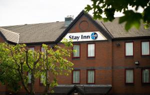 a red brick building with a stay inn sign on it at Stay Inn Manchester in Manchester