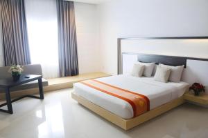 a bedroom with a large white bed and a table at Buana Lestari Hotel in Klandasan Kecil +68 photos