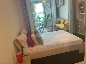 a bed with pillows on it in a bedroom at Studio Vanille - Vue Mer in Saint-Denis