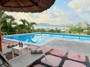 a resort pool with a view of the water at Departamentos Frente al Mar en Ixtapa in Ixtapa