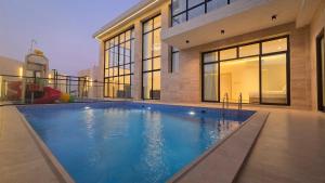 a large swimming pool in front of a house at Al Mona Resort 2 شاليه المنى in Al Khobar