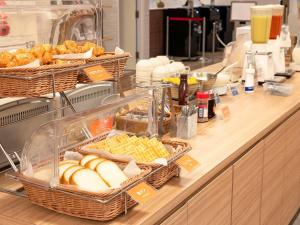 a buffet with baskets of food on a counter at Comfort Hotel Hachinohe in Hachinohe +22 photos