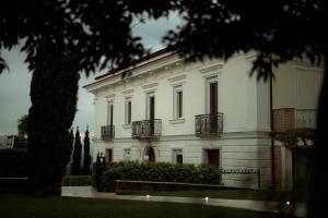 een wit gebouw met een boom ervoor bij Palazzo Pecci in San Leucio del Sannio +8 foto's
