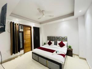 Un dormitorio con una cama grande con almohadas rojas. en Hotel Milton -Malviya Nagar, en Gurgaon