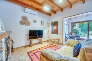a living room with a couch and a tv at Villa Delfin in Manacor