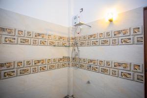 a bathroom with a shower with tiles on the wall at The Cloud Nest Villa in Ahangama +28 photos