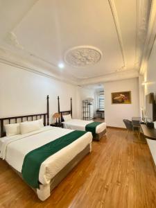 Khách Sạn Thủ Đô Formerly Impressive Hotel في هانوي: غرفة فندقية بسريرين ومكتب
