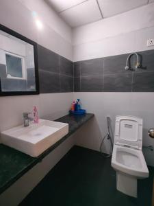 un baño con lavabo e inodoro en Paramount Luxury Apartment, en Greater Noida