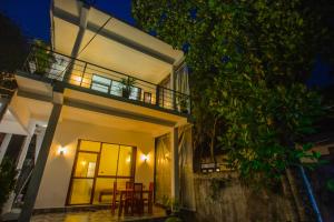 a house with a balcony at night at The Cloud Nest Villa in Ahangama