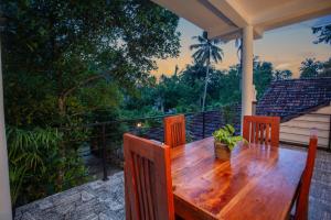 a wooden table and chairs on a deck with a view at The Cloud Nest Villa in Ahangama