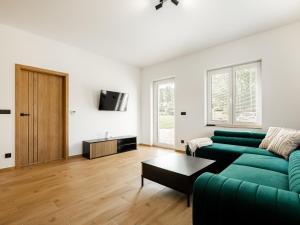 a living room with a green couch and a table at Apartmány Bližší Lhota in Bližší Lhota