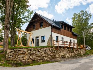 a house with a stone wall and a wooden roof at Apartmány Bližší Lhota in Bližší Lhota