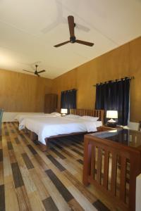 a bedroom with a large bed and a ceiling fan at Coffee Courtyard in Kurchi