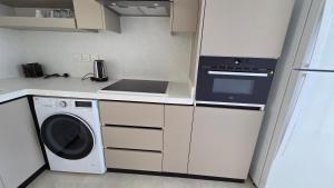 a kitchen with a washer and a stove top oven at Al Mona Resort 2 شاليه المنى in Al Khobar