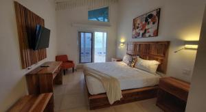 Merrils Deluxe في نيغريل: غرفة نوم بها سرير وتلفزيون