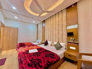 a bedroom with a large bed with a red blanket at The Kridha Palace in Ayodhya