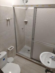 Un baño con ducha, inodoro y lavabo. en Leño Verde, en Espinal