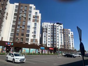a car parked in a parking lot in front of tall buildings at Причал in Chişinău