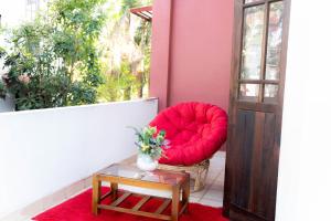 a red chair sitting on a balcony with a table at Singha Residences Thalawathugoda in Bokundara