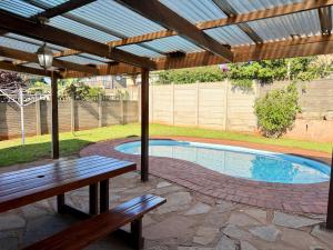 a patio with a bench and a swimming pool at Kingfish Cove, Pennington in Kelso