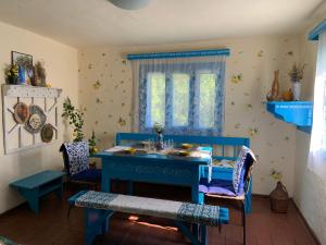 a dining room with a blue table and chairs at La Verona in Finciu