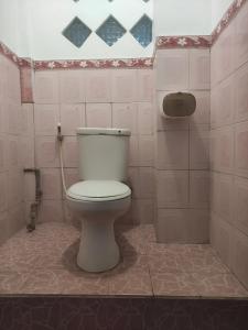 a bathroom with a white toilet in a room at Hotel Dupa in Lovina
