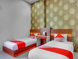 Habitación con 2 camas en rojo y blanco en OYO 3157 Grand City Inn, en Pampang 73 fotos más