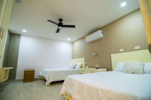 a bedroom with two beds and a ceiling fan at Summer Bay Luxury Suite - West End - Roatán in Coxen Hole
