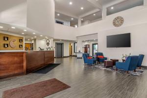 an office lobby with a reception desk and blue chairs at Comfort Suites Hattiesburg near University in Hattiesburg