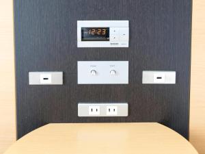 un orologio su un muro accanto a un tavolo di Comfort Hotel Hamamatsu a Hamamatsu Altre 34 foto