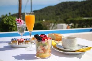 a table with a glass of juice and a bowl of fruit at Hotel Rural Can Maries in Puerto de San Miguel