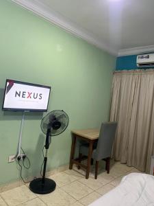 Una habitación con un escritorio y un cartel que dice nuevos nosotros en Dominion Apartment and Guest House, 