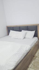 Una cama con sábanas blancas y almohadas. en Dominion Apartment and Guest House,  4 fotos más