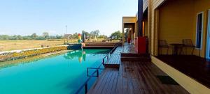 a porch of a building with a pool of blue water at ห่มฟ้าโพธิ์แค้มป์ปิ้ง in Ban Wang Sak