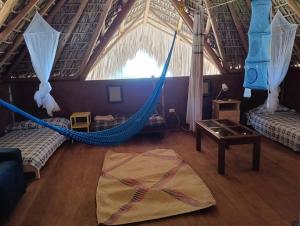 a room with two beds and a hammock at Villa Naila in San Agustinillo