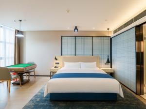 a bedroom with a bed and a pool table at Echarm Hotel Xiangyang Erqi in Xiangfanbei +182 photos
