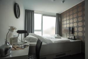 um quarto com uma cama, uma escrivaninha e uma janela em Stravinsky Slapen em Hengelo mais 15 fotografias