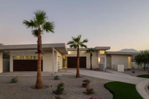 a house with palm trees in front of it at Cobalt @ Elemento49 Pool Spa Sleeps 16 in Desert Groves Mobile Home Park