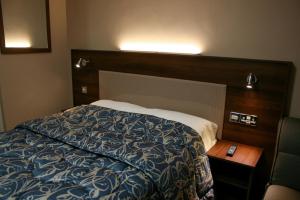 a bedroom with a bed and a wooden head board at Stay Inn Manchester in Manchester