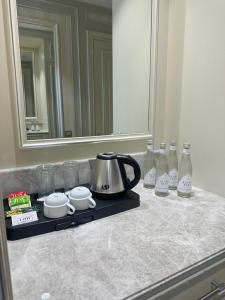 a counter top with a tea kettle and bottles of milk at Oq uy Hostel Chilonzor in Tashkent