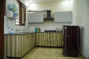 2BHK Luxury Villa In Mohali 1ST FLOOR - Stay Royal في Mohali: مطبخ مع خزائن خشبية وثلاجة +20 صورة
