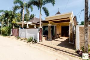 a house with palm trees in front of it at Aonang Soi 1 Villa 2bedroom2bathroom in Ao Nang Beach