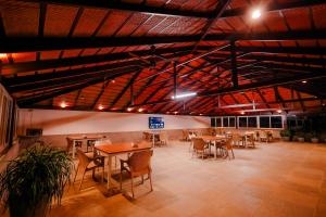 uma sala de jantar com mesas, cadeiras e luzes em The Odyssey Coorg em Madikeri