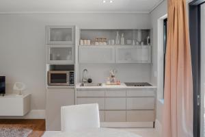 The gallery luxury one bedroom apartment unit 101 في كنيسنا: مطبخ أبيض مع دواليب بيضاء وميكرويف