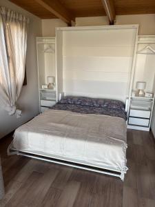 een slaapkamer met een groot bed met witte muren en houten vloeren bij Dependance Con Giardino A Pescara in Pescara
