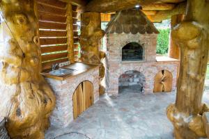 a kitchen with a fireplace and a sink in a house at Village Cottage - Koča na vasi in Nazarje