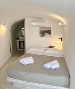 a bedroom with two beds with towels on it at Fira Heart Studios in Fira